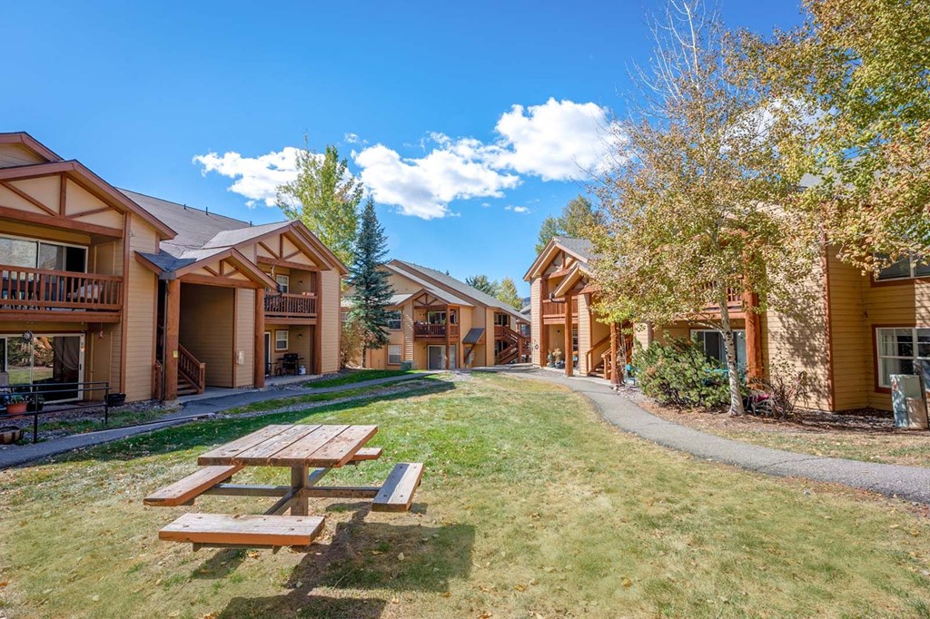 a picnic table in front of a group of buildings