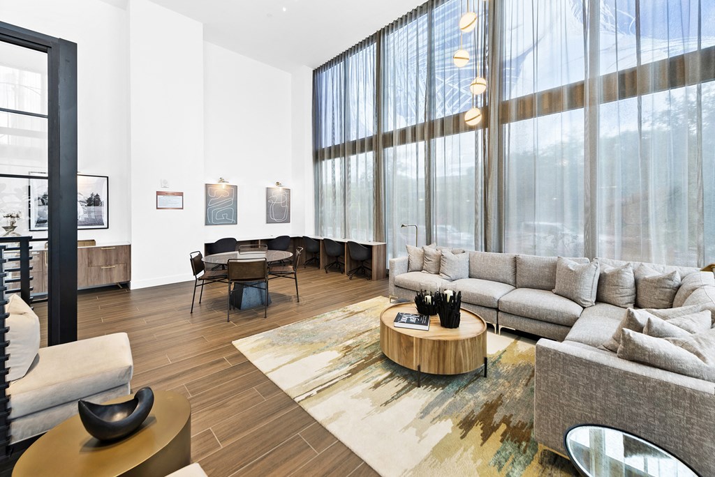 a living room with white walls and large windows