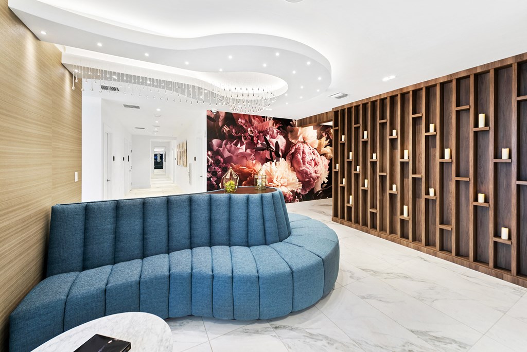 a rendering of a lobby with a blue couch and a large floral mural on the wall