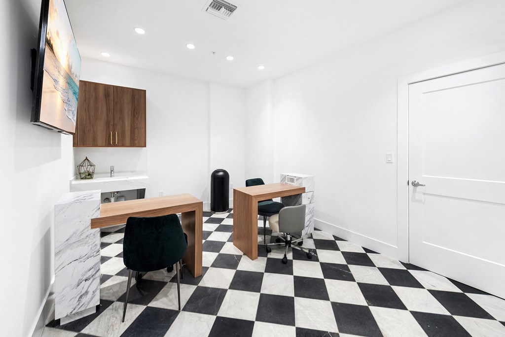 a room with a checkerboard floor and two desks