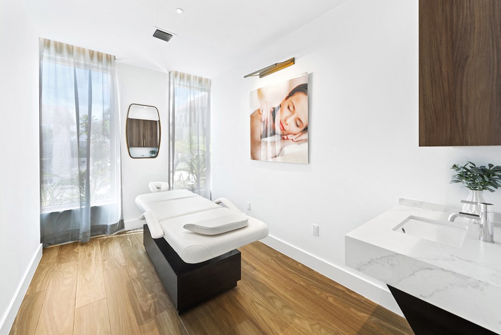 a spa room with a massage table and sink