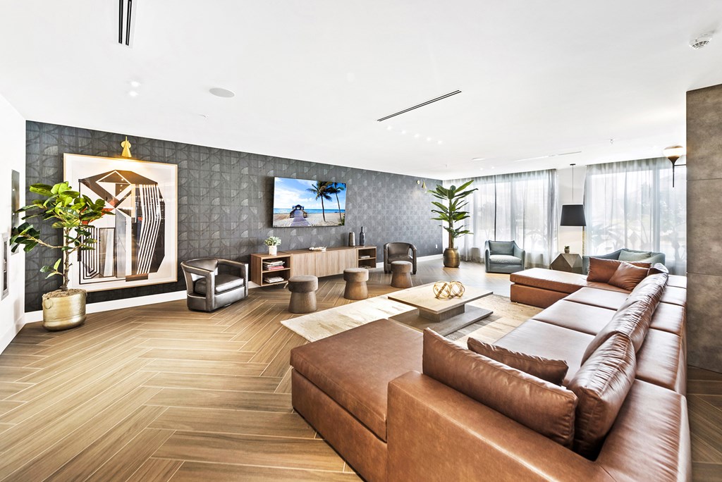 a living room with a large brown couch and a flat screen tv on the wall