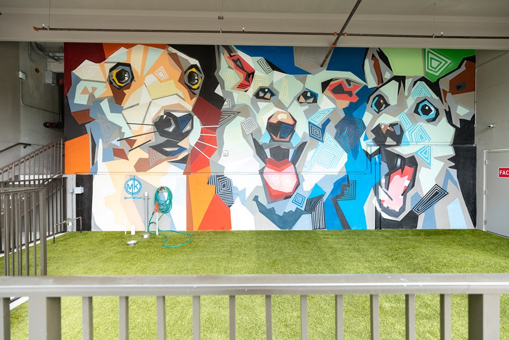 a mural of dogs is displayed on the wall of a building