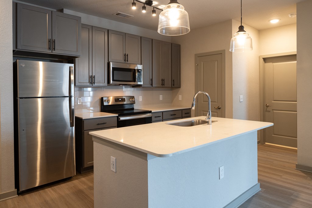 a kitchen with stainless steel appliances and a white counter top