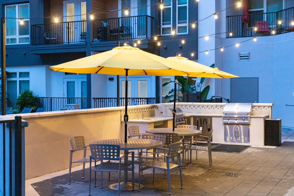 a patio with yellow umbrellas and tables with chairs
