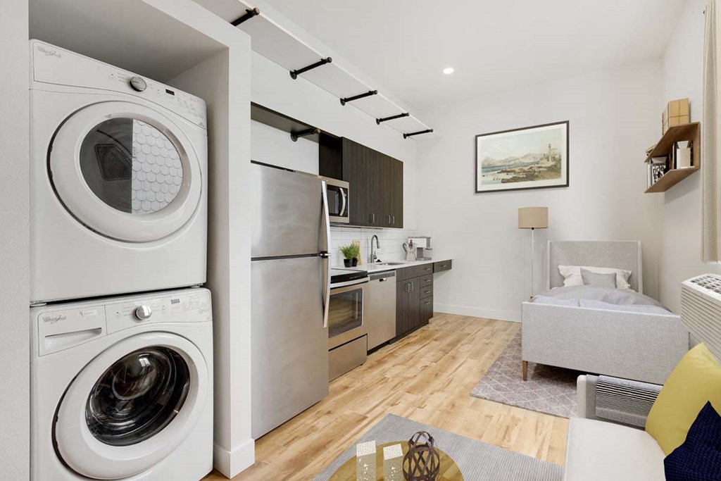 a washer and dryer in a living room next to a kitchen