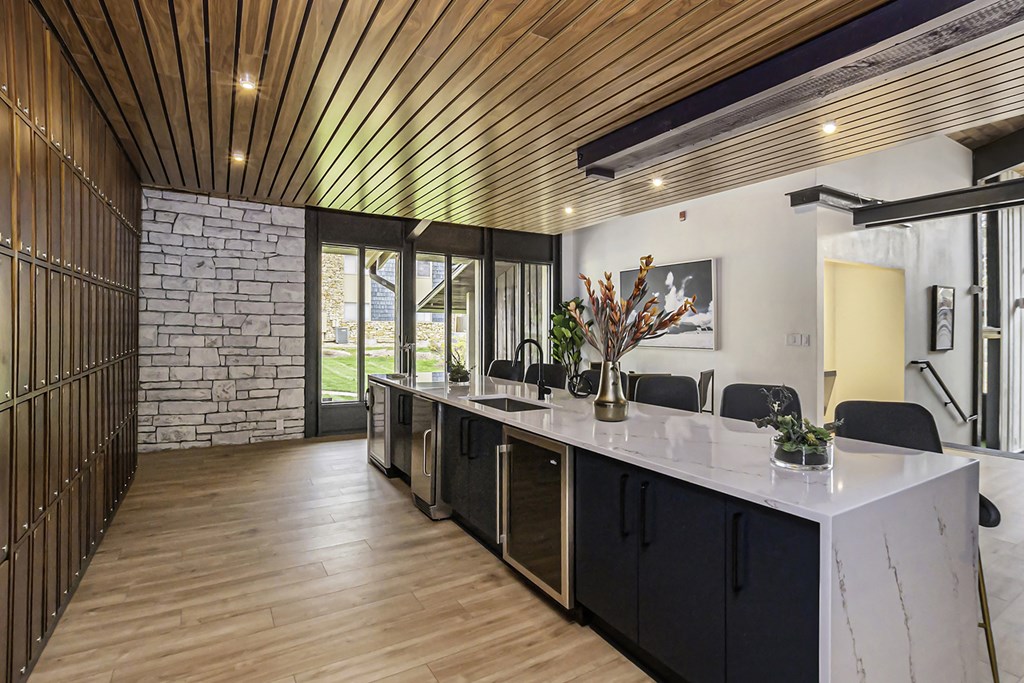 a kitchen with a long counter and a stone wall