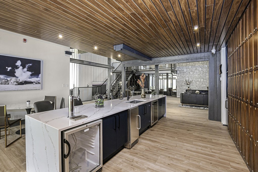 a kitchen with a long counter and a living room in the background