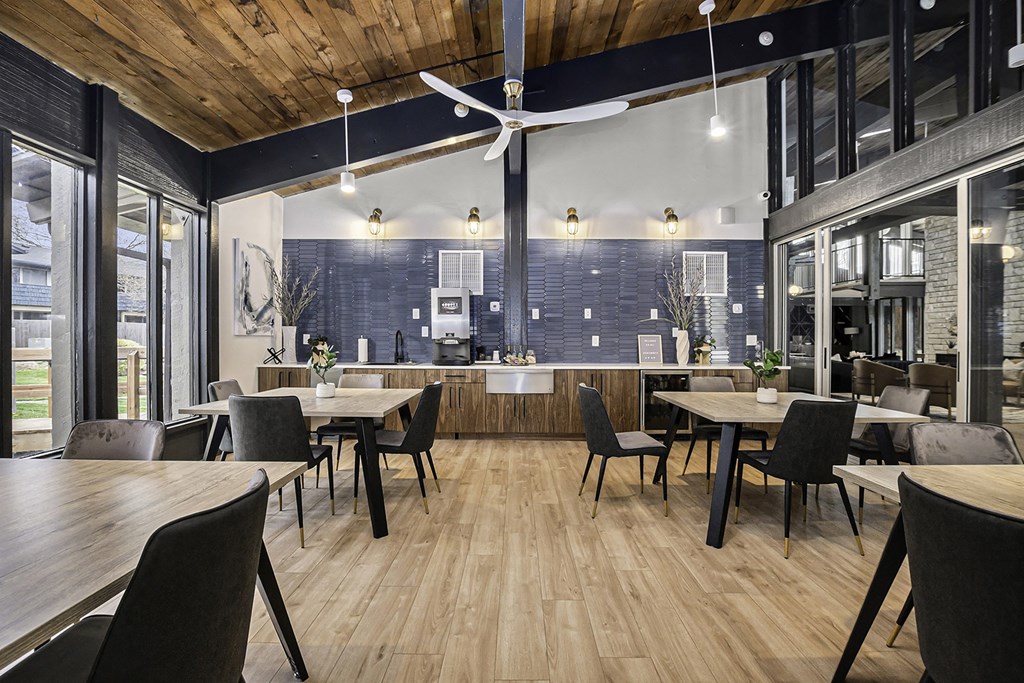 a dining room with tables and chairs and a kitchen