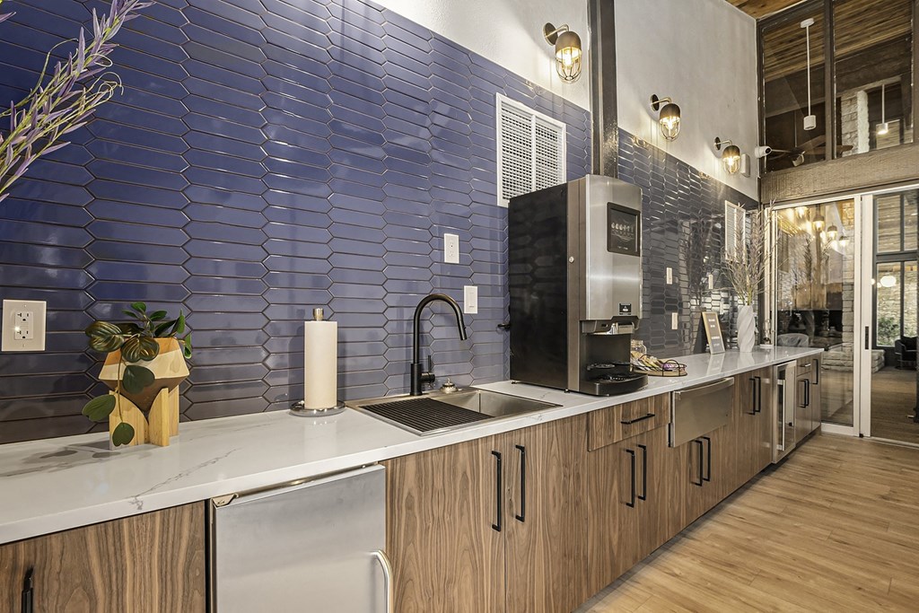 a kitchen with a blue tile wall and a sink