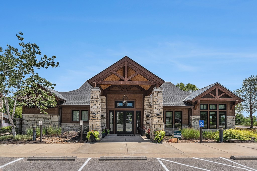 a large brown building with a gray and brown roof with a blue sky in the background
