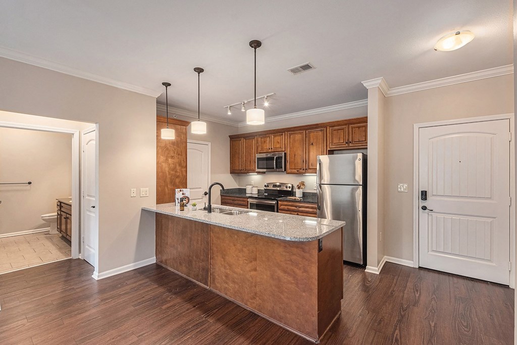 a kitchen with a large island and stainless steel appliances
