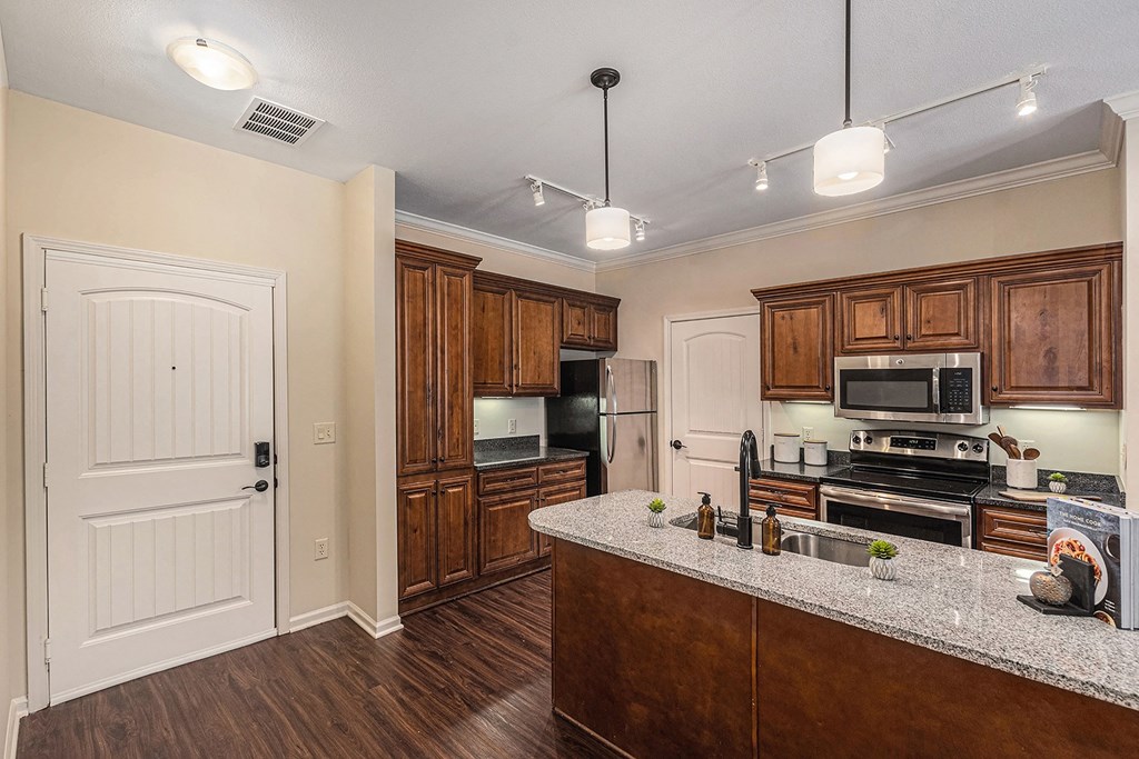 a kitchen with wooden cabinets and a granite counter top