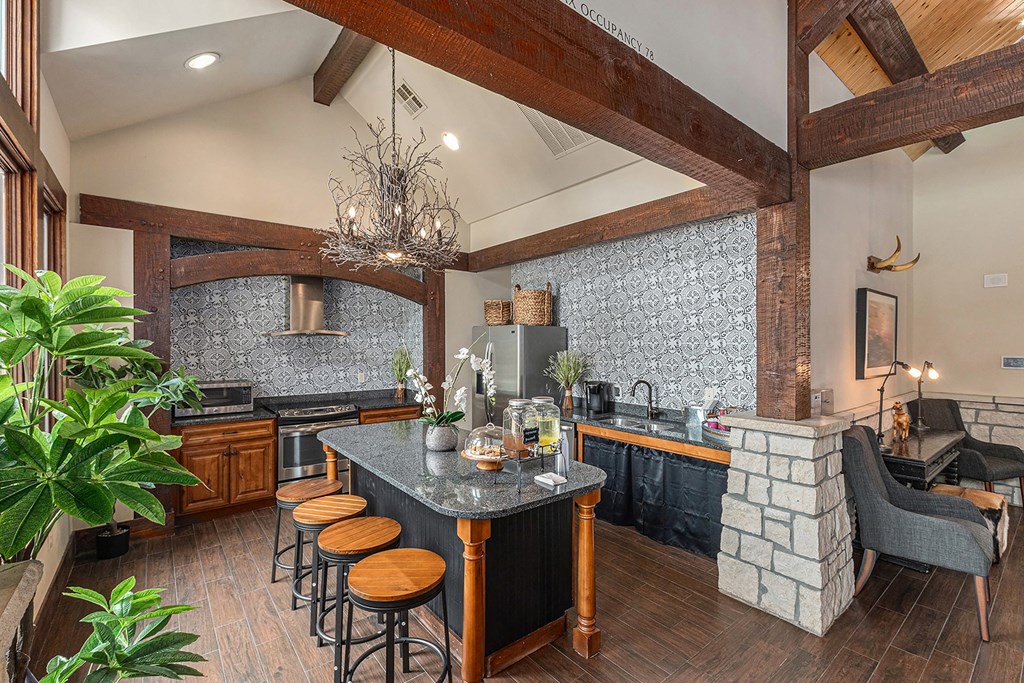 a kitchen with a long island with stools and a fireplace