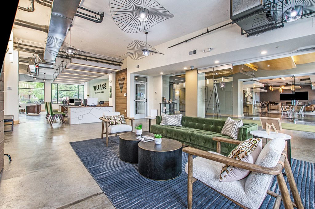 a lobby with a green couch and tables