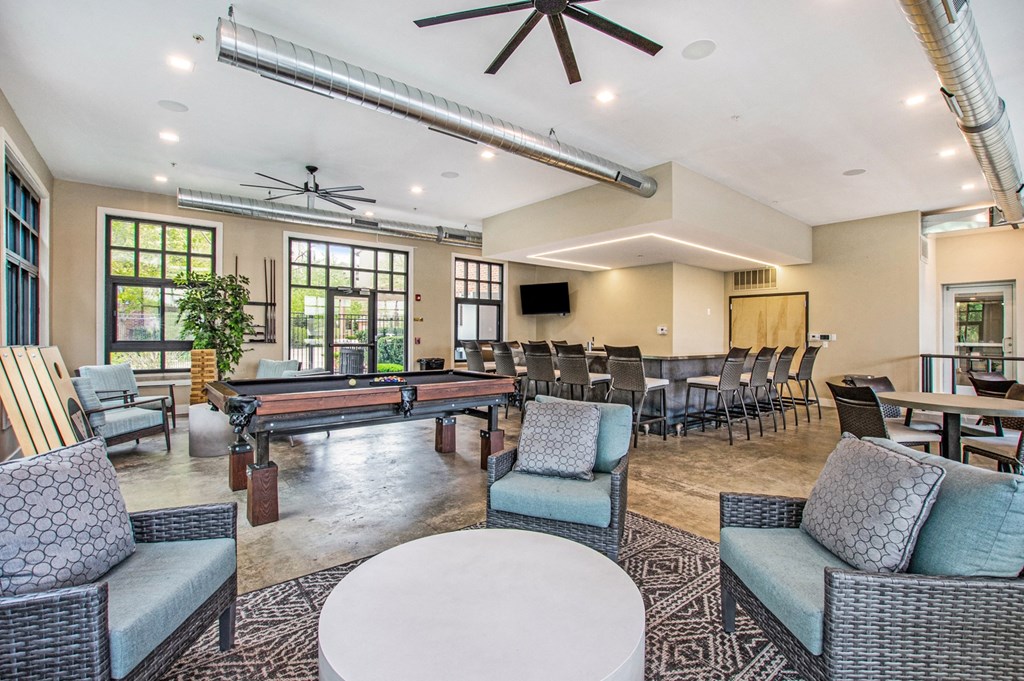 a lounge area with a pool table and chairs