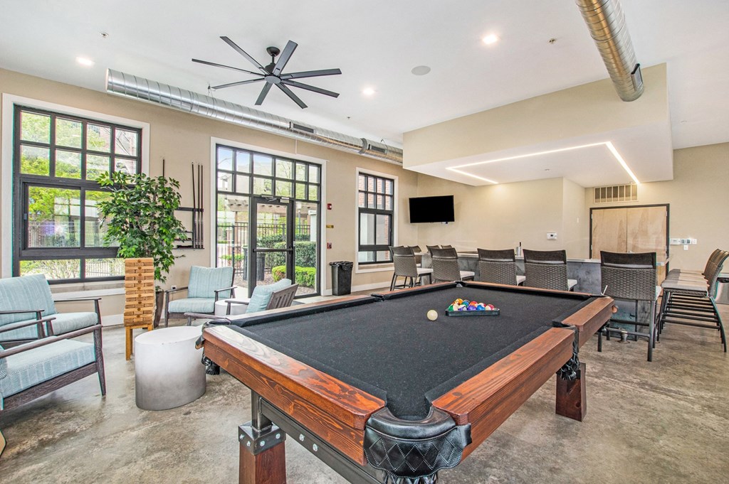 a community room with a pool table and chairs