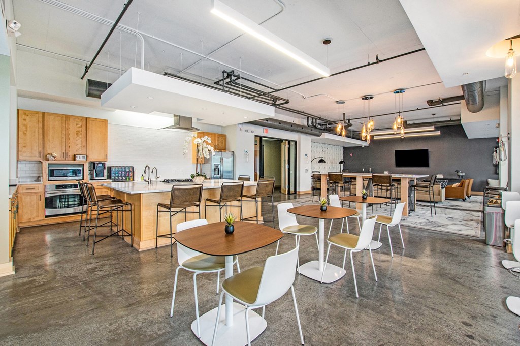 a large dining room with tables and chairs and a kitchen
