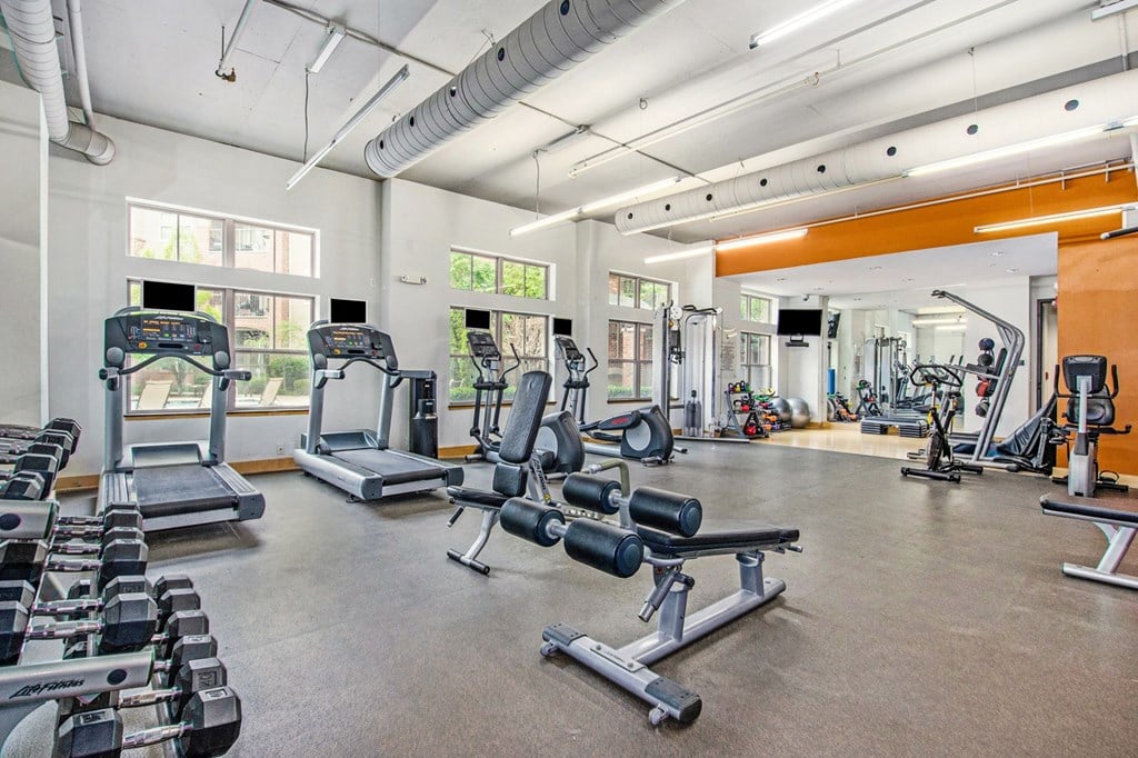 a gym with cardio machines and weights on the floor