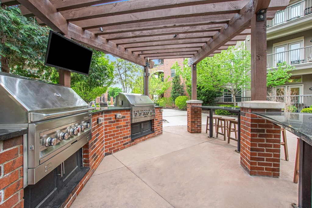 a patio with a barbecue grill and a pergola