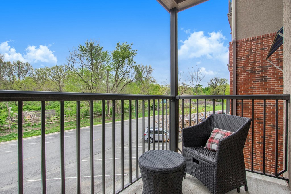 a patio with a chair and a table on a balcony