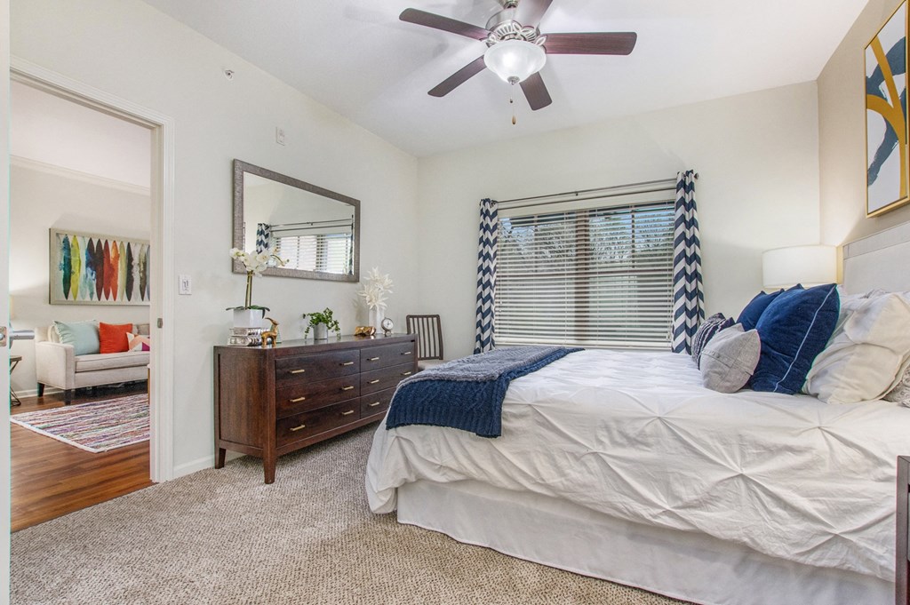 a bedroom with a large bed and a ceiling fan