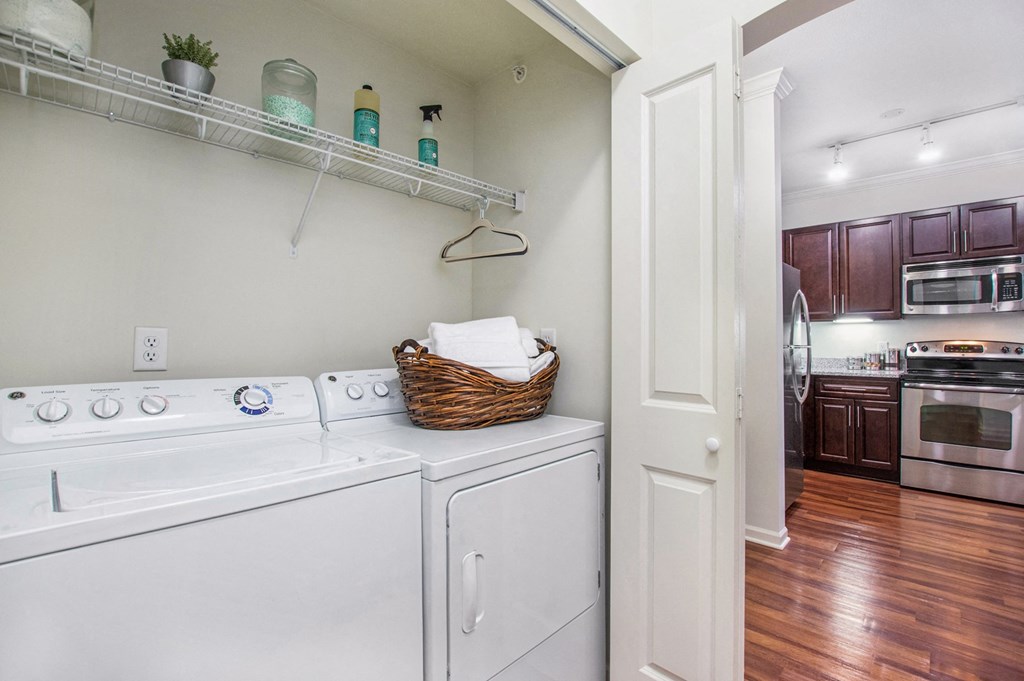 a white washer and dryer in a kitchen with wood flooring