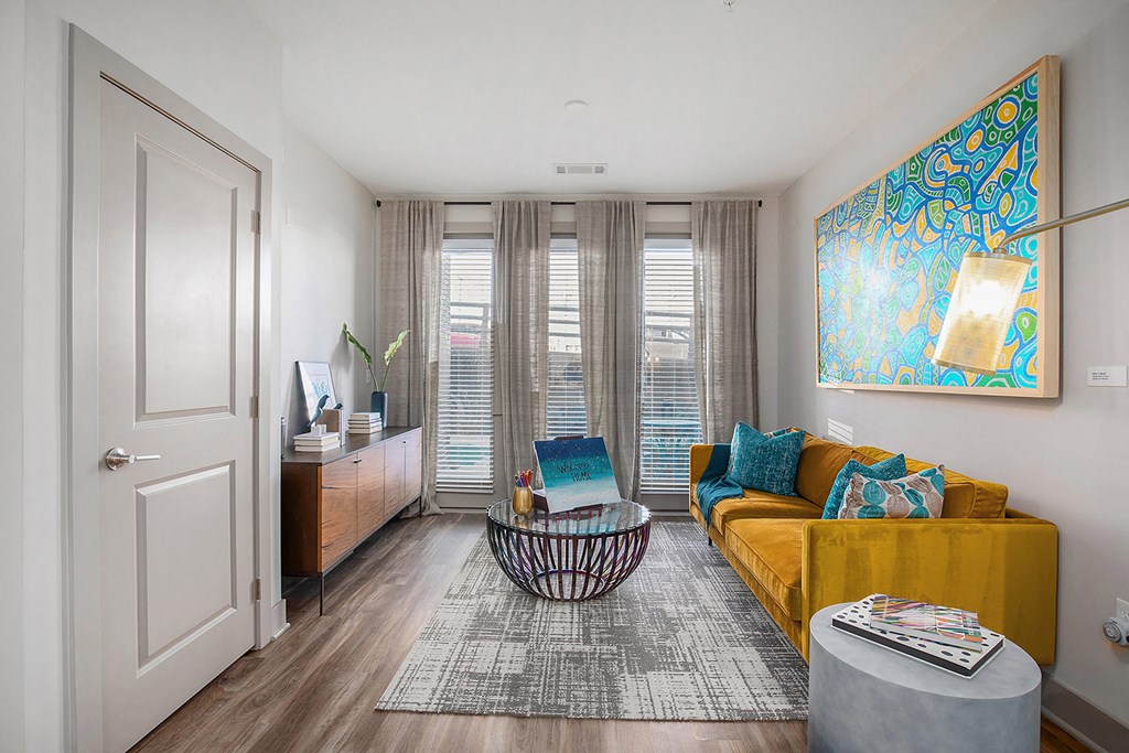a living room with a yellow couch and a table