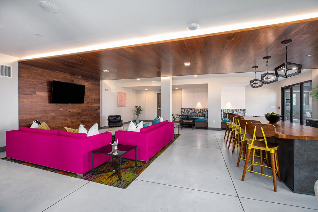 a living room with a pink couch and a table and chairs