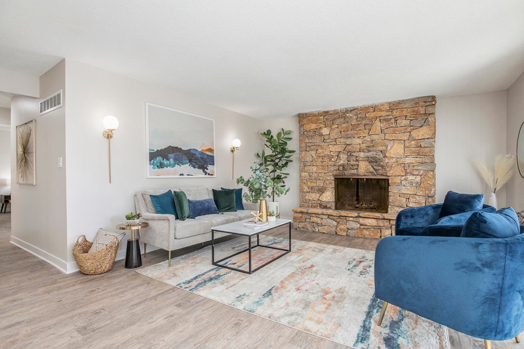 a living room with a blue couch and a stone fireplace