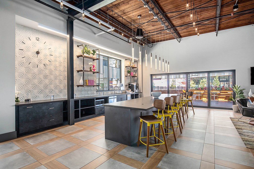 a large kitchen with yellow bar stools and a table with chairs