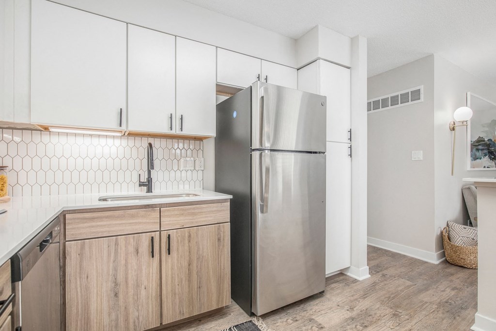 a kitchen with white cabinets and a stainless steel refrigerator