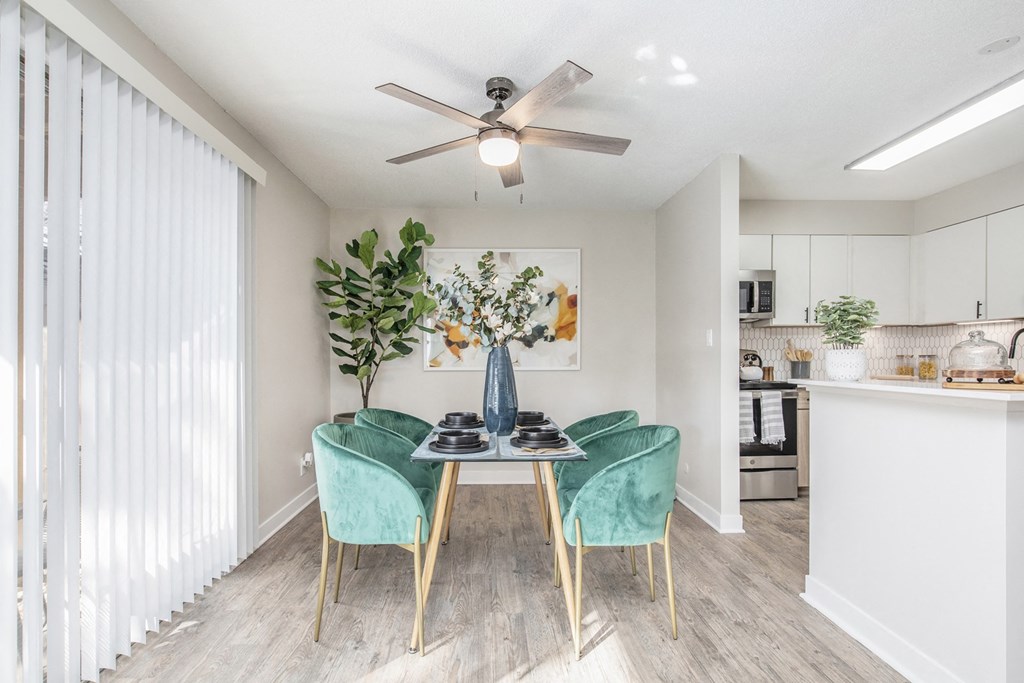 a dining room with a table and chairs and a ceiling fan