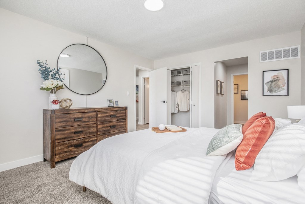 a bedroom with a large bed and a mirror