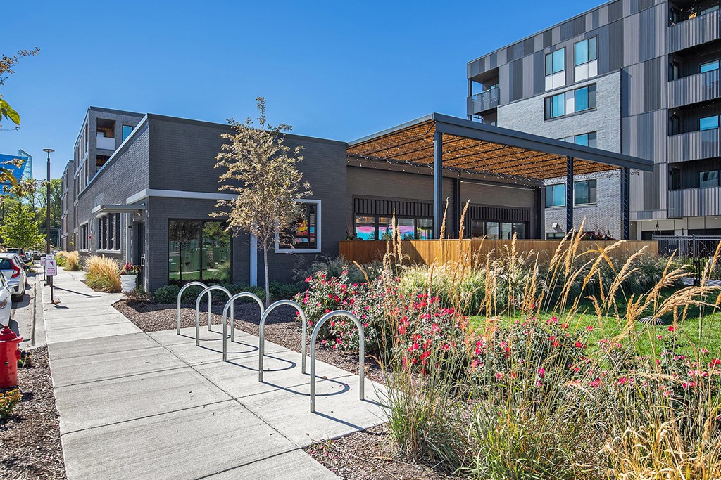 a sidewalk in front of a building with colorful flowers