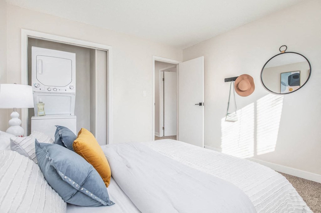 a bedroom with a bed and a closet      and a mirror