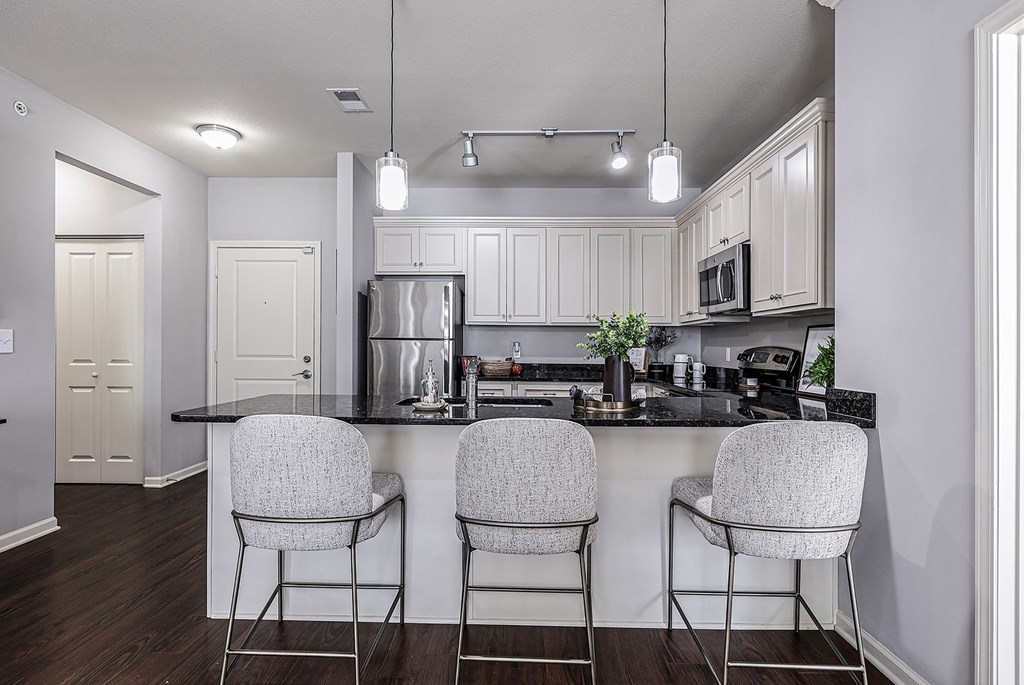 an open kitchen with a bar with three stools