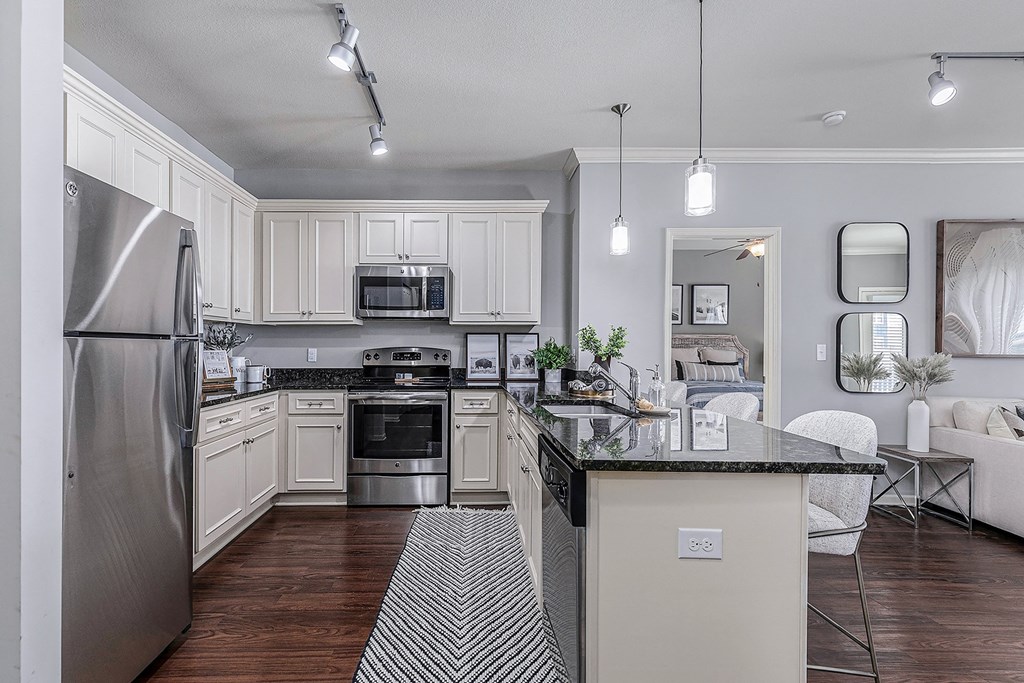 a spacious kitchen with stainless steel appliances and white cabinets