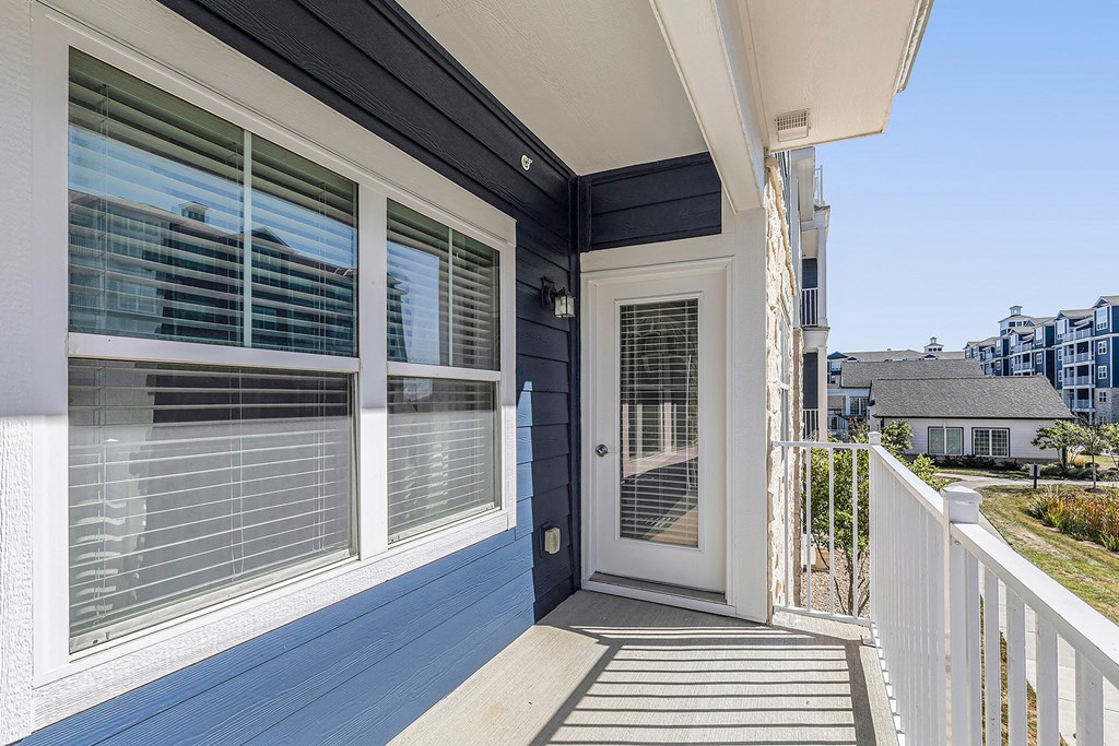 a view of the front door of a house with windows and a balcony