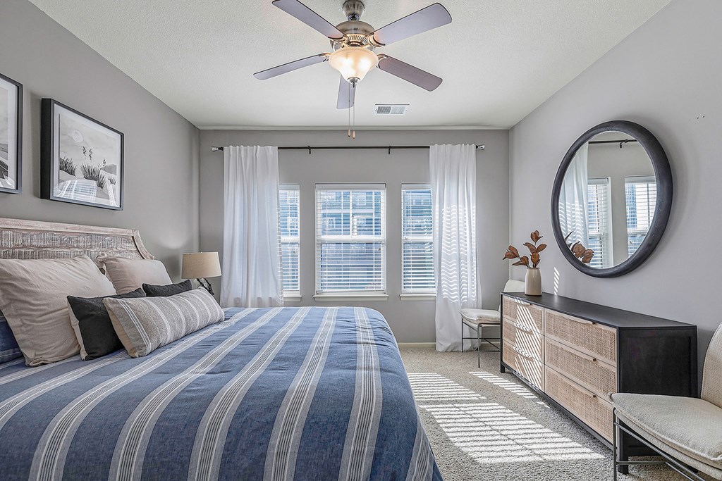 a bedroom with a large bed and a ceiling fan