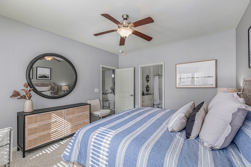 the master bedroom has a large bed and a ceiling fan