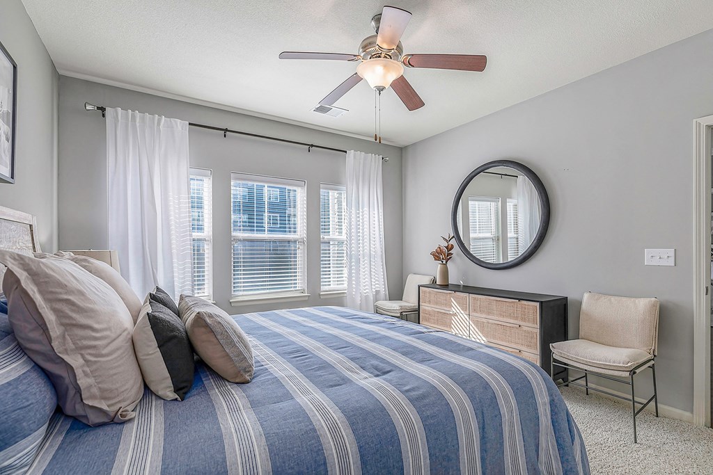 a bedroom with a large bed and a ceiling fan