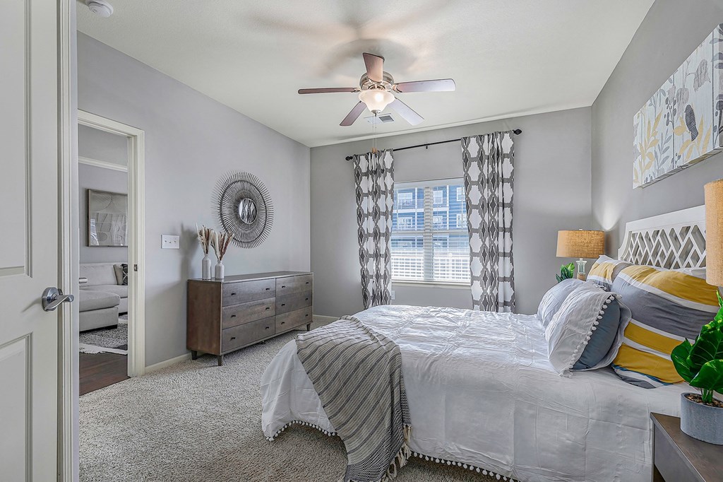 a bedroom with a large bed and a ceiling fan