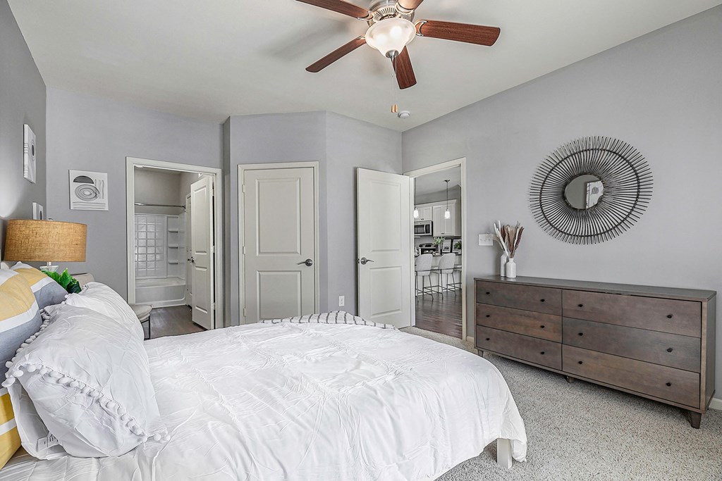 a bedroom with a large bed and a ceiling fan