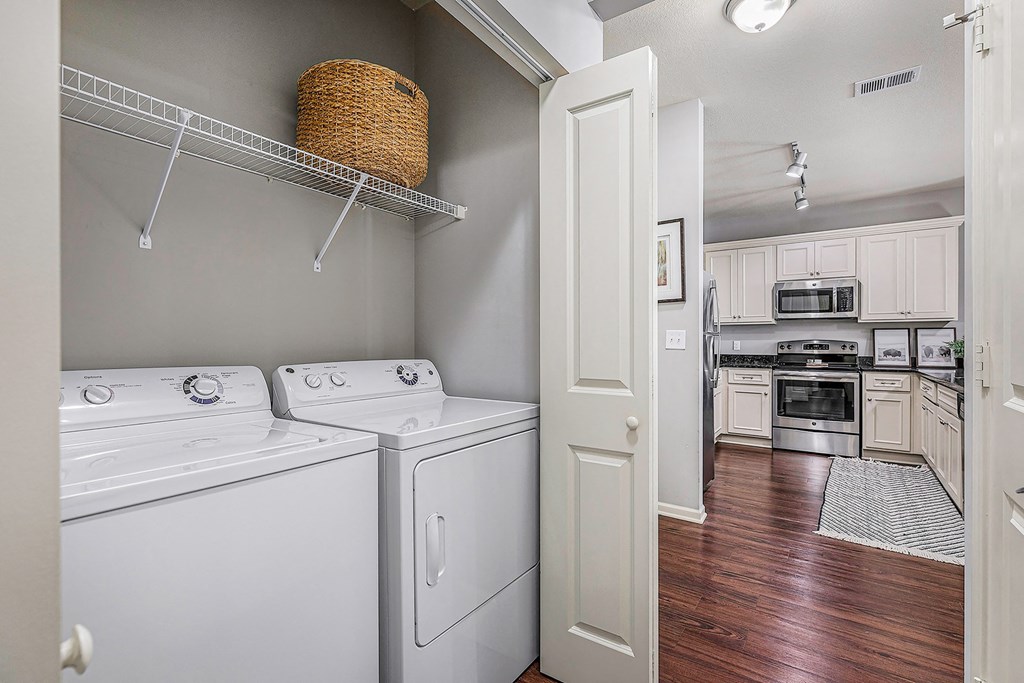 a spacious kitchen with white appliances and a laundry room with a door to the kitchen