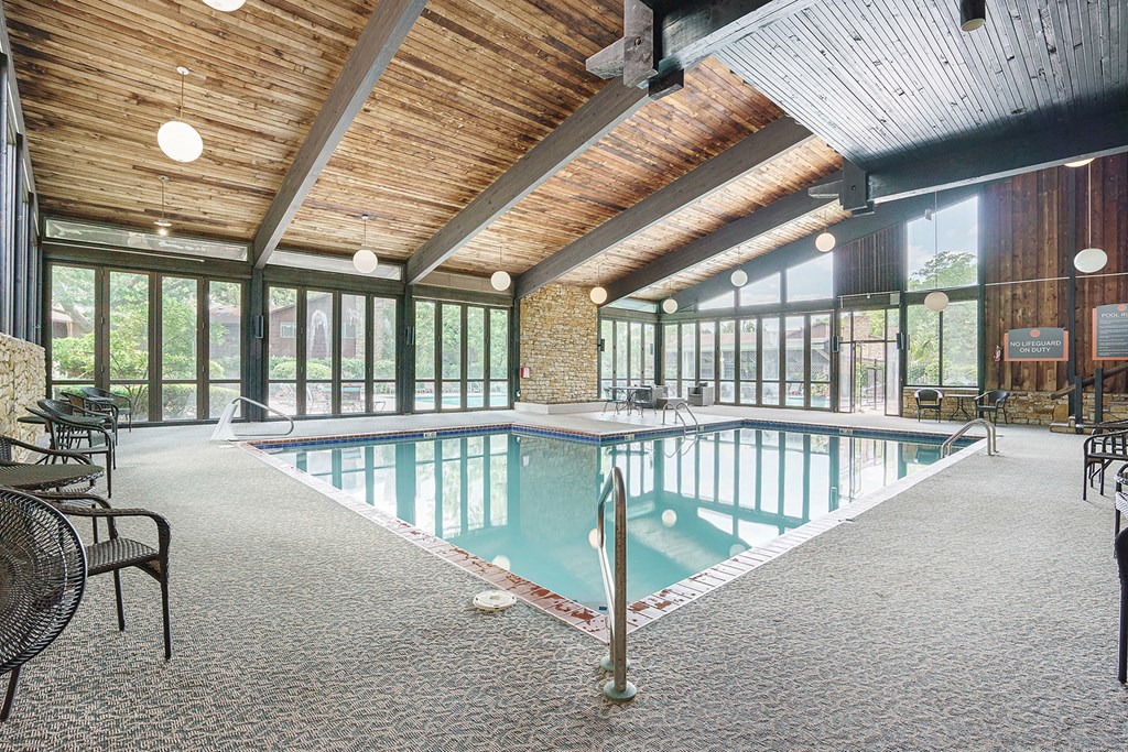 a swimming pool with a wooden ceiling and glass walls