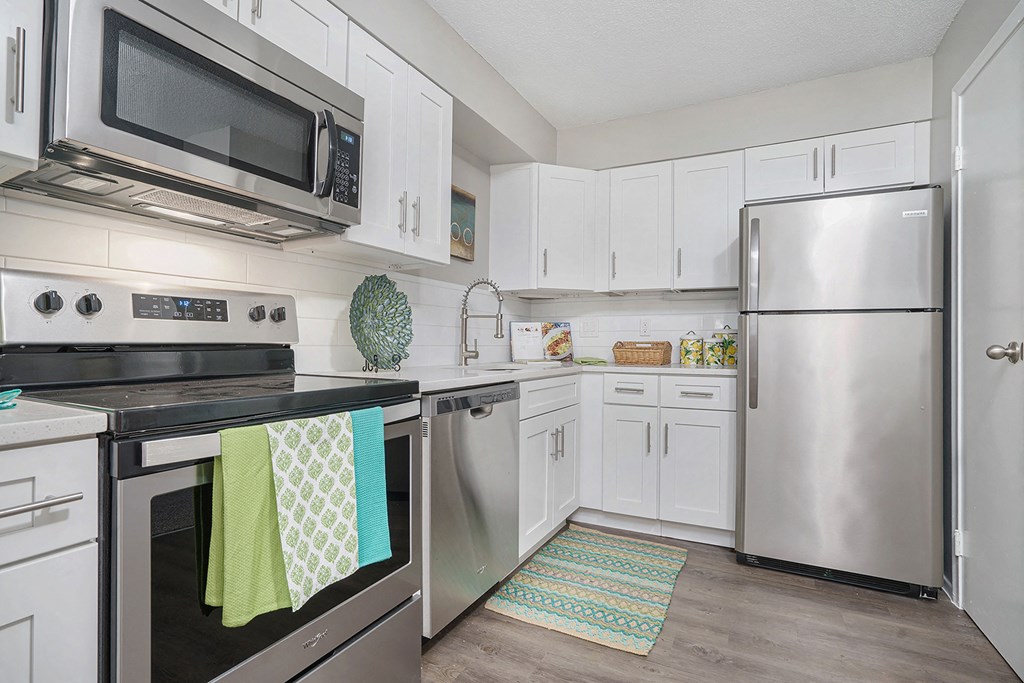 a kitchen with stainless steel appliances and white cabinets