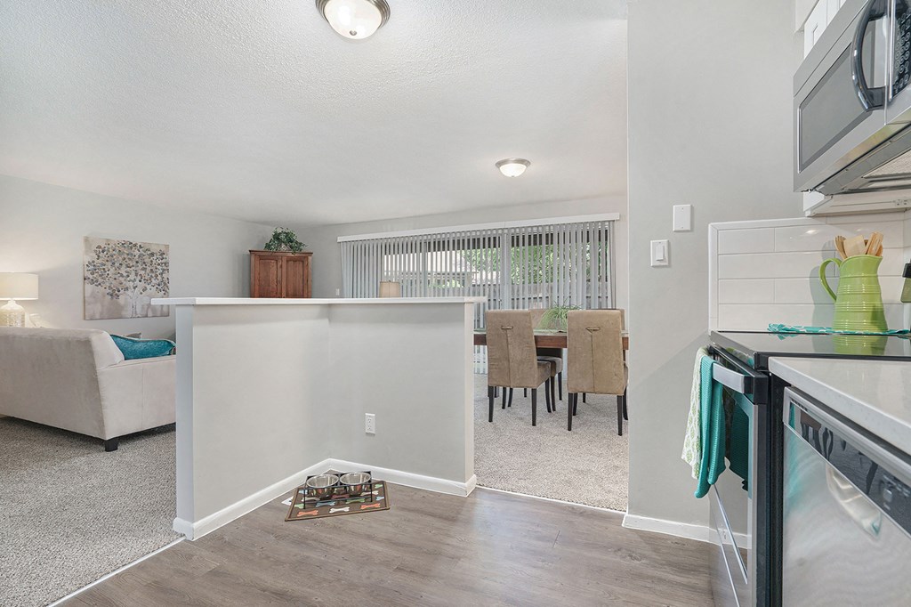 the kitchen and dining area of a renovated home with a white kitchen counter top and
