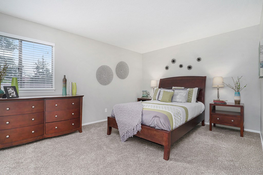 a bedroom with a bed and two dressers