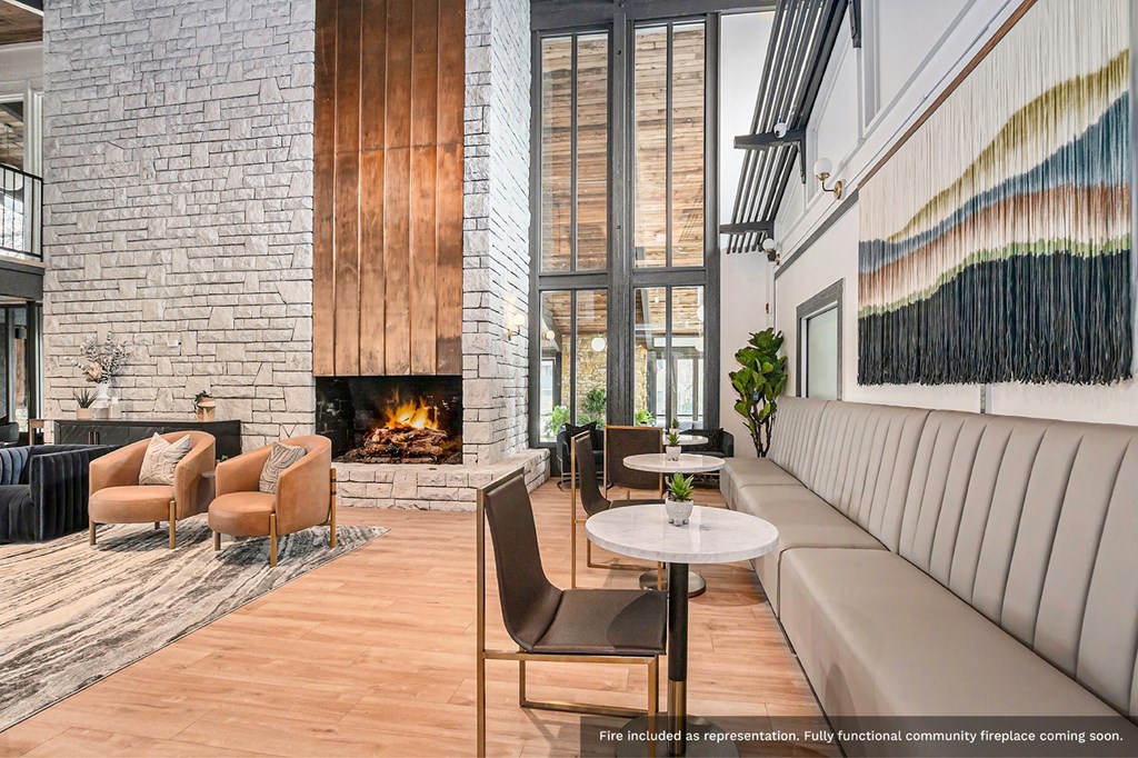 a living room with a fireplace and tables and chairs